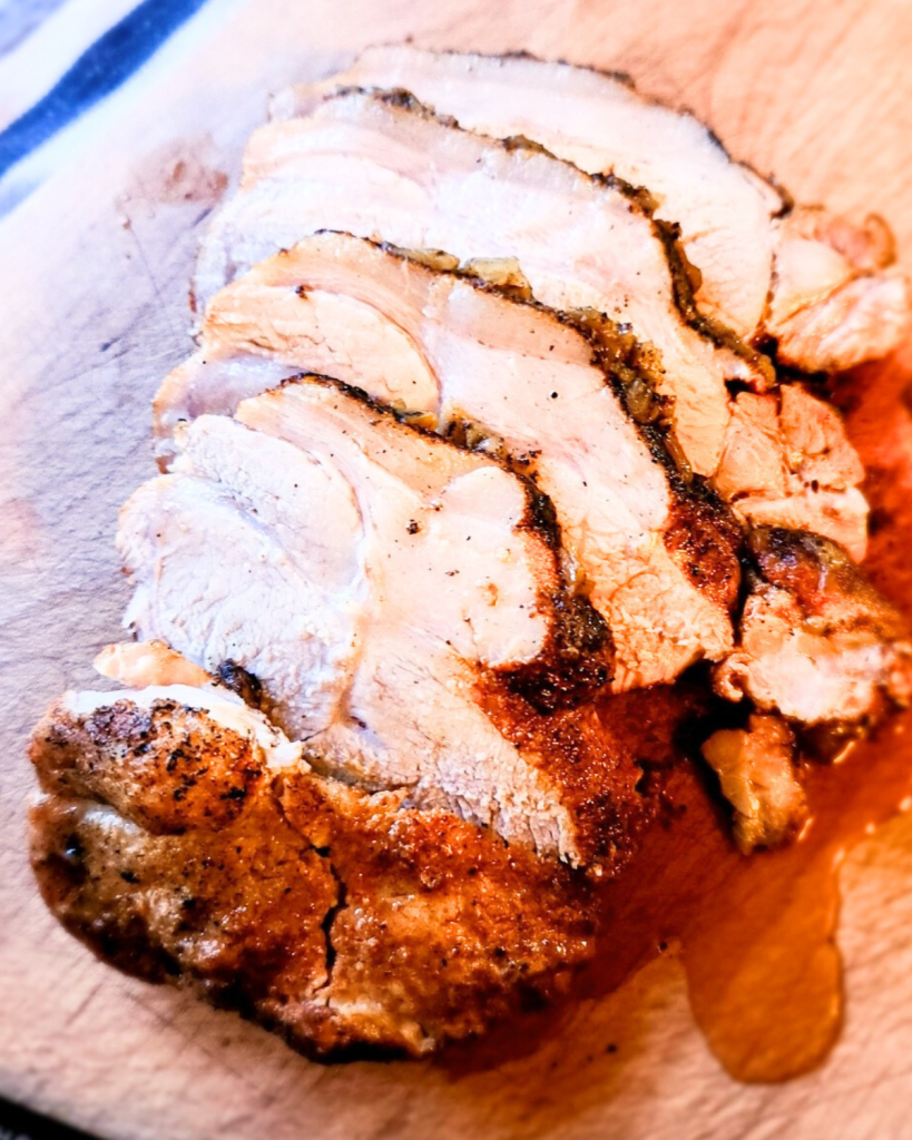 Roasted pork loin cut on a cutting board.