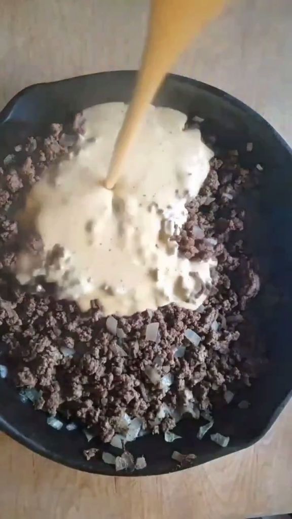 Pouring homemade cream soup into the ground beef.
