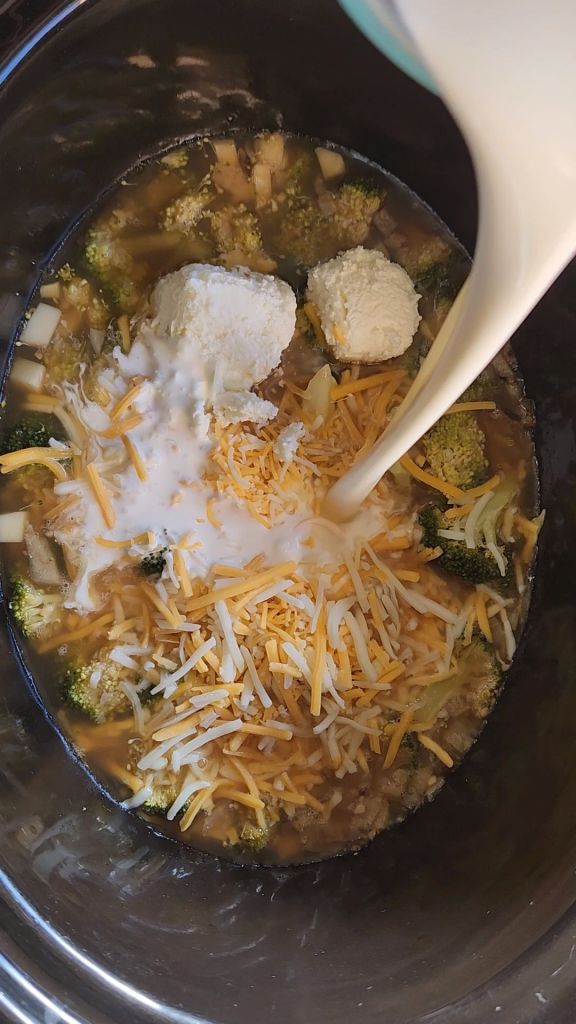 stirring in heavy cream, cream cheese and cheddar cheese into the crockpot.