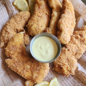 A basket of air fryer keto chicken strips with a bowl of low carb honey mustard