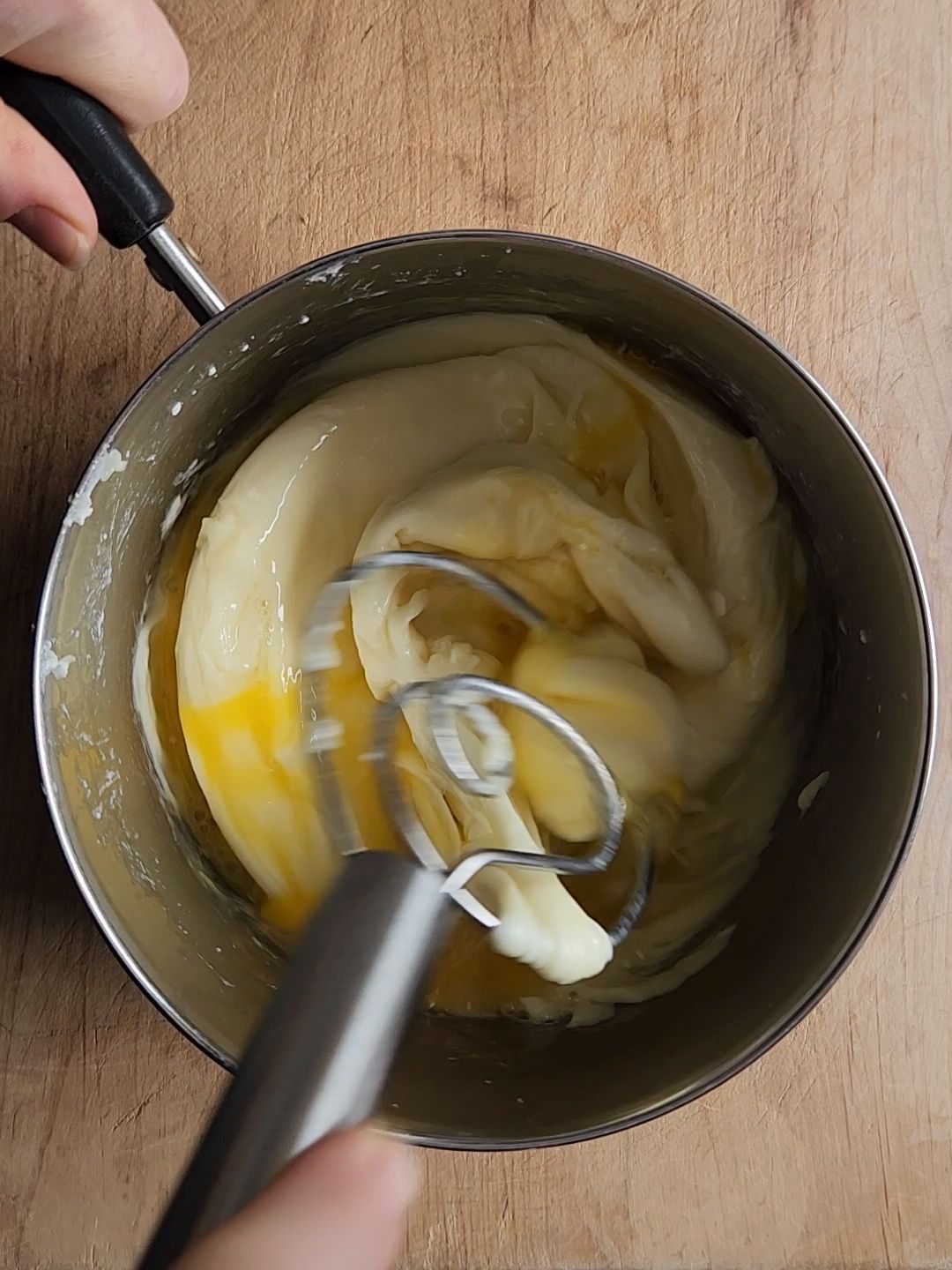Mixing eggs into the melted cheeses for the crust.