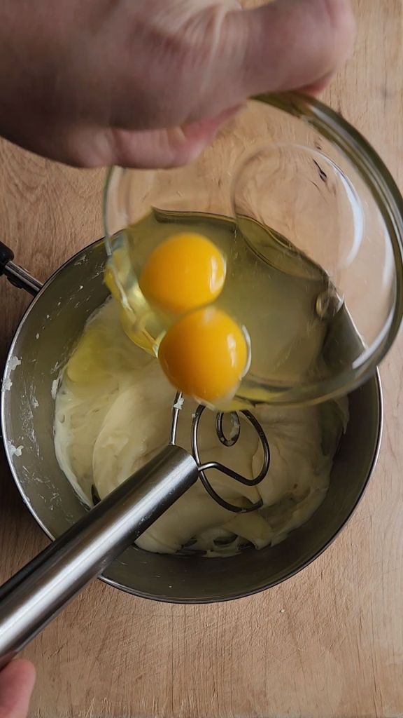 Pouring eggs into the melted cheeses.