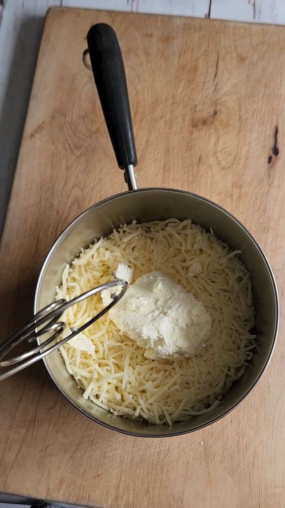 Cream cheese and mozzarella in a saucepan for melting.