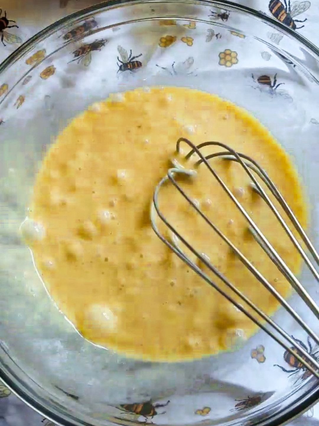 Bakery style gluten free chocolate chip keto muffins batter in a bowl with a whisk.