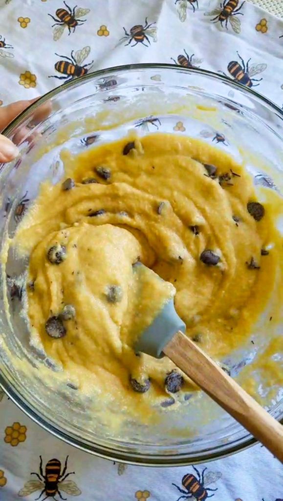 Folding sugar free chocolate chips into the batter for Bakery style gluten-free chocolate chip muffins.