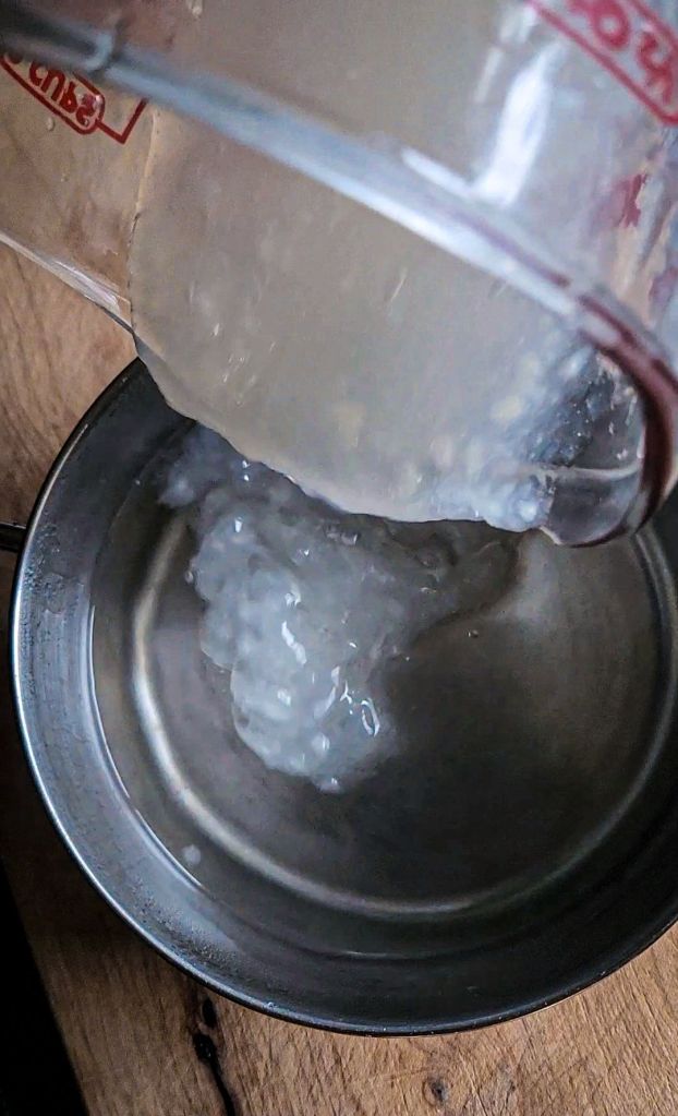 Mixing xanthan gum mixture into the main saucepan for keto friendly honey substitute.