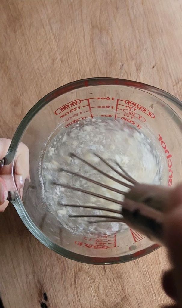 Mixing warm water with xantham gum to make the xanthan gum mixture.