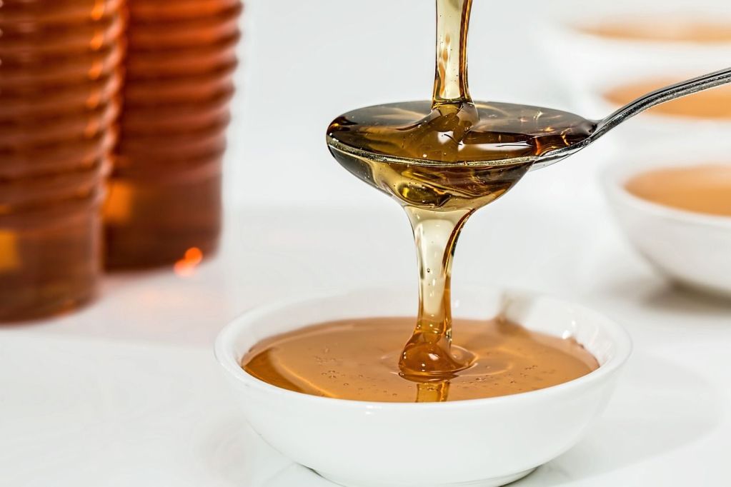 Real honey dripping from a spoon.