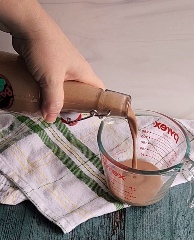Measuring low-carb Bailey's copycat Irish Cream into a measuring cup to make low carb Baileys Irish Cream coffee creamer recipe.