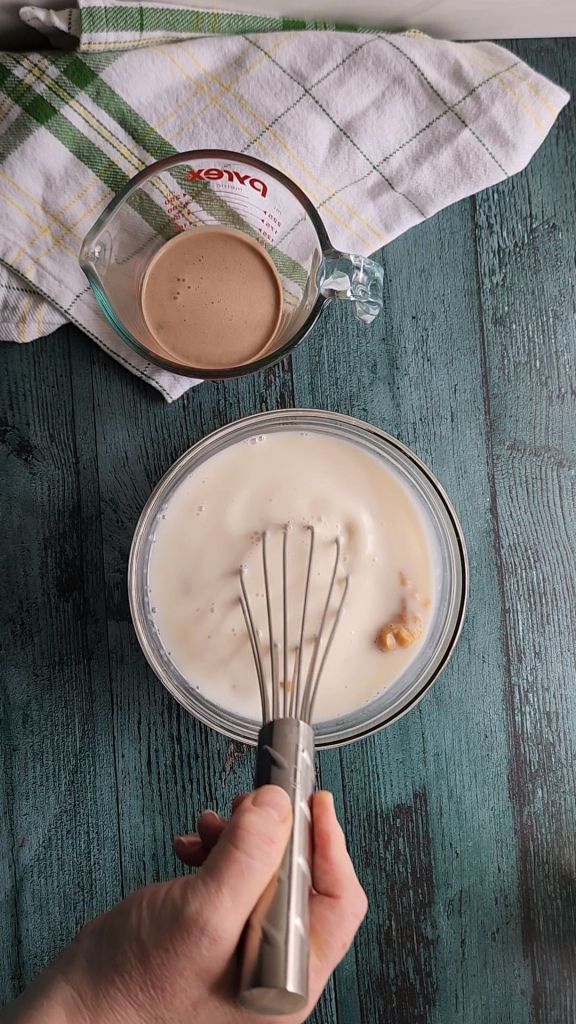 Combining unsweetened almond milk with sweetened condensed milk to make low carb Baileys Irish Cream coffee creamer recipe.