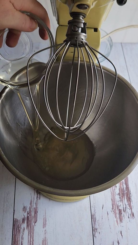 Adding melted coconut oil to the mixing bowl with the keto honey substitute.