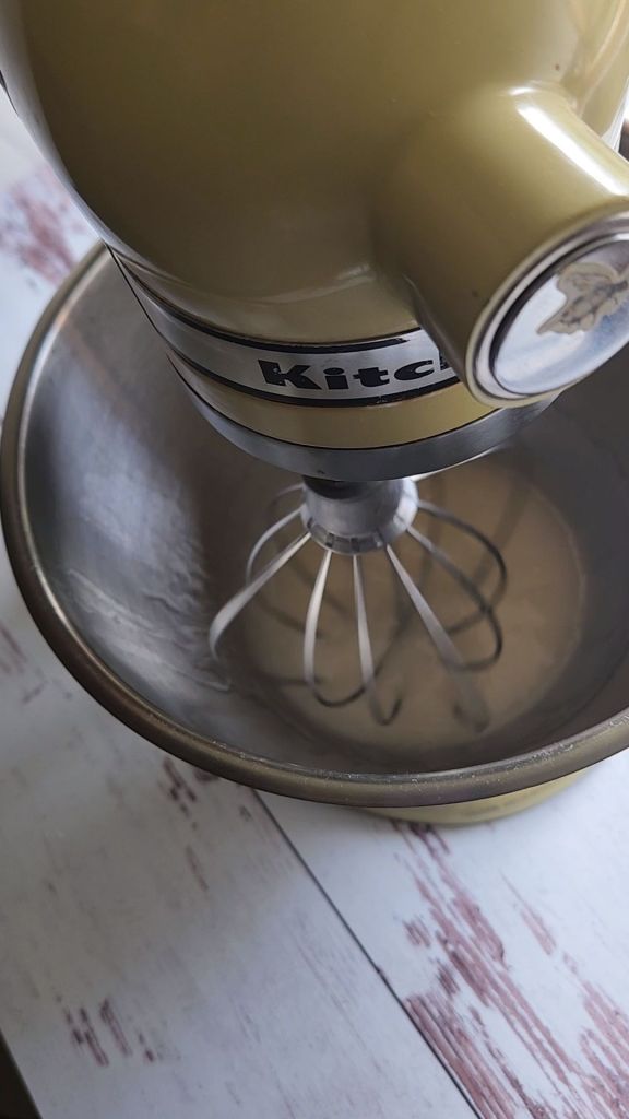 Whisking keto honey substitute and melted coconut oil to make the best gluten-free strawberry cake recipe.