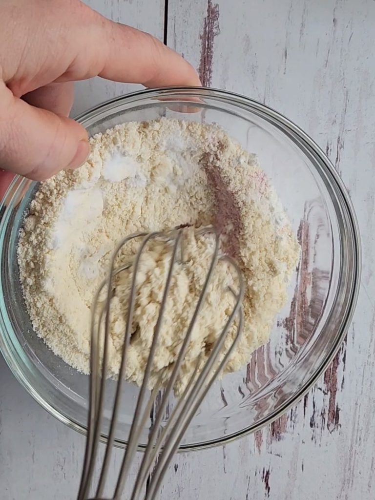 Whisking ingredients for the best gluten-free strawberry pudding cake recipe.