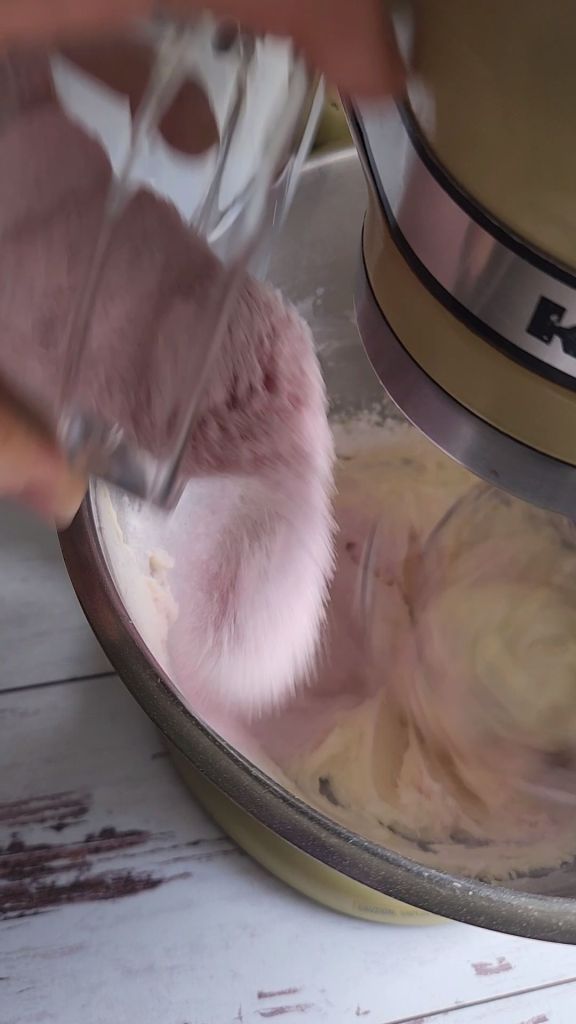 Pouring a package of sugar-free strawberry pudding into the frosting recipe.