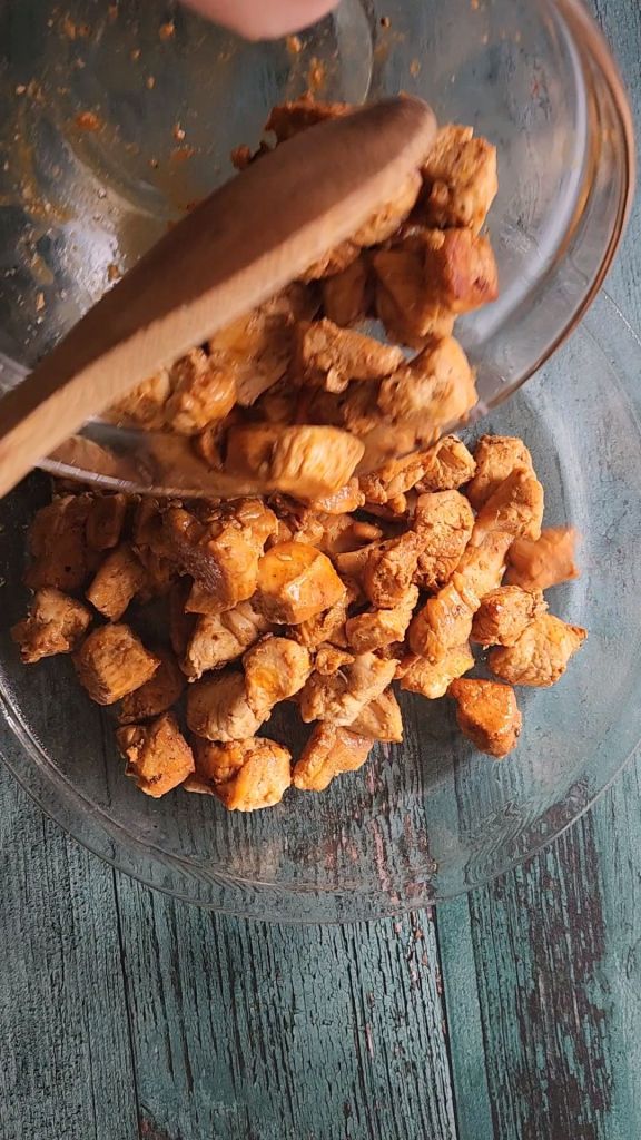 Pouring cooked chicken into pie plate.