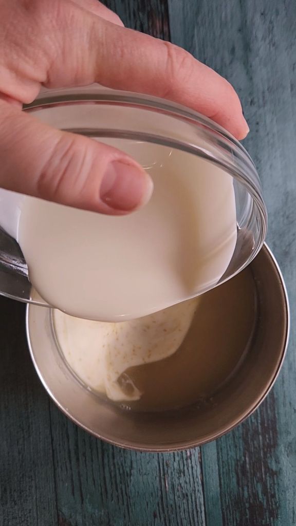 Pouring heavy cream into saucepan.