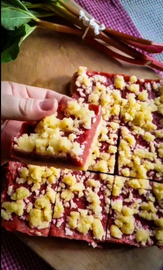 Showing a cut piece of gluten-free strawberry rhubarb crumble bars recipe.