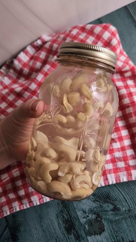Raw cashews in a quart jar filled with water for soaking.
