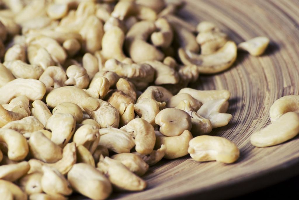 Raw cashew nuts on a plate.