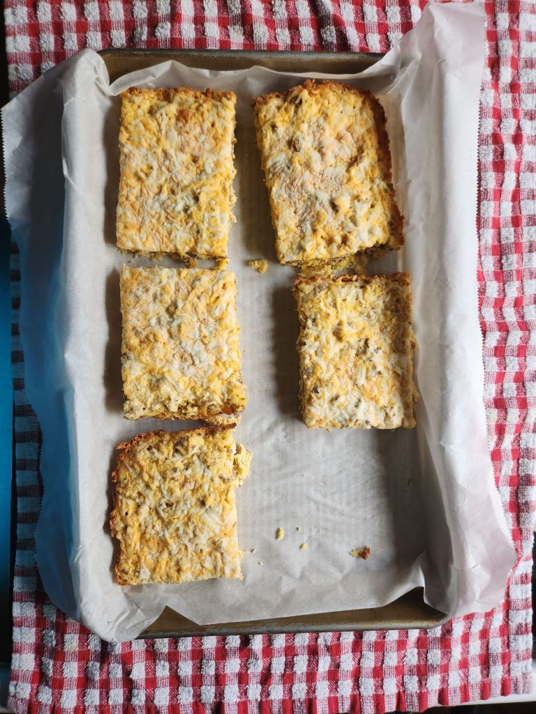 Flash freezing keto sausage bars on a parchment lined pan.