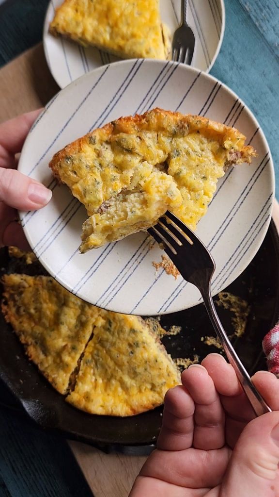 A bite of low carb sausage and cheese frittata on the end of a fork.