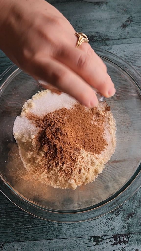 Adding cinnamon to dry ingredients for Grandma's gluten-free cinnamon coffee cake recipe.