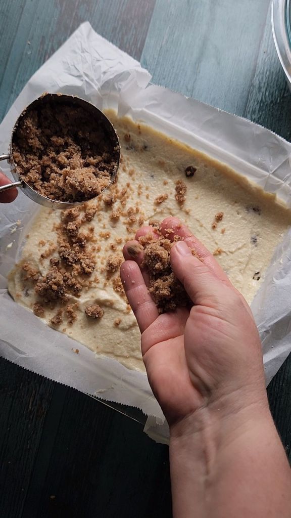 Adding third layer of struedel to the pan of Grandma's gluten free cinnamon coffee cake recipe.