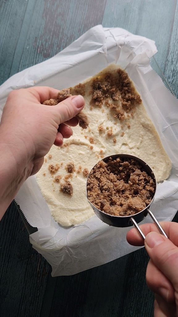 Adding first layer of strudel to the pan of Grandma's gluten free cinnamon coffee cake recipe.