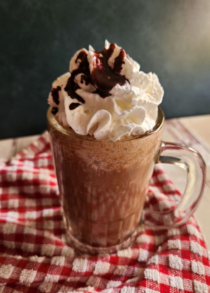 Prepared low carb copycat Starbucks caramel mocha Frappuccino topped with whipped cream and chocolate syrup.