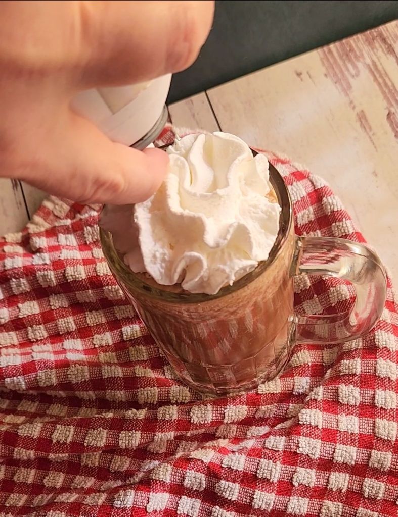 Topping a low carb copycat Starbucks with caramel mocha Frappuccino with whipped cream.