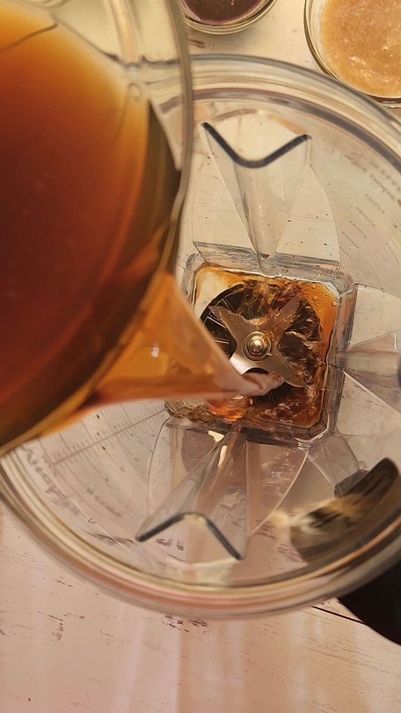 Pouring cold coffee into the blender to make a low carb copycat Starbucks caramel mocha Frappuccino.