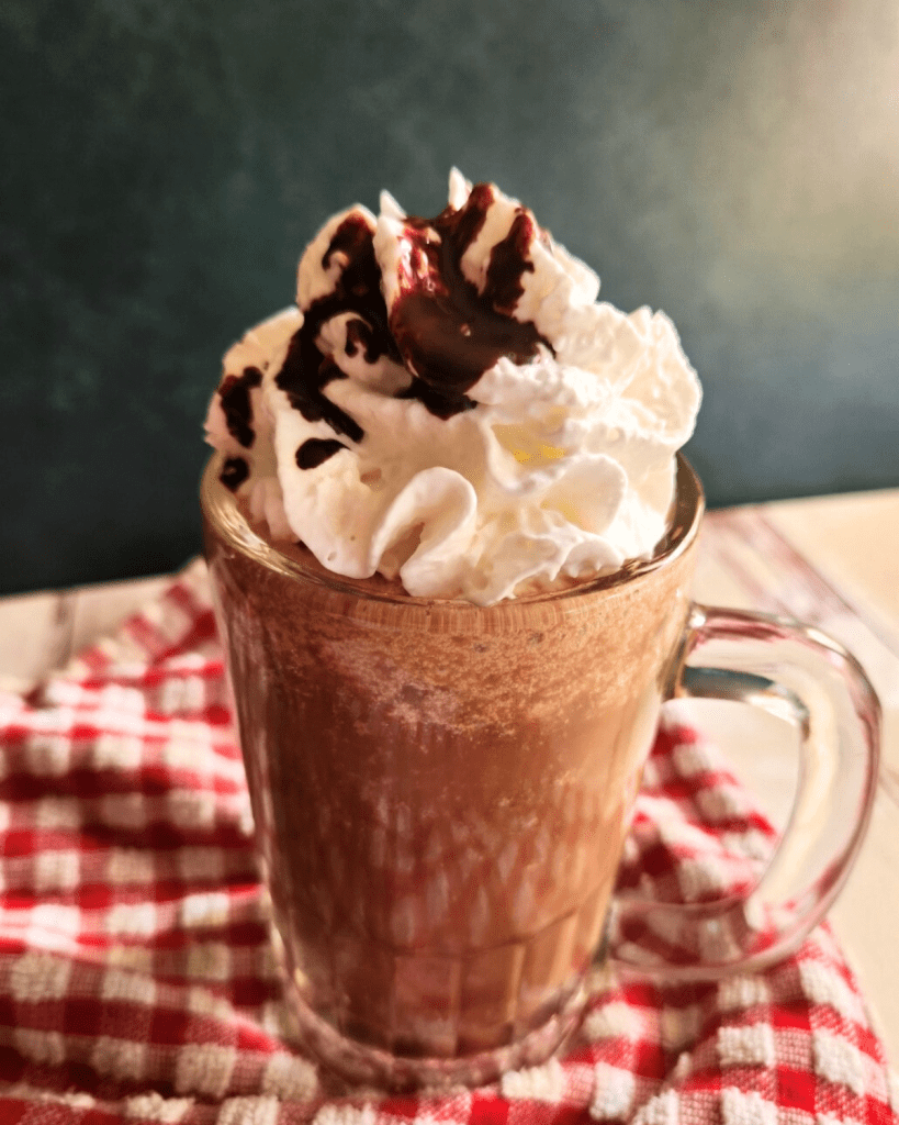 Prepared low carb copycat Starbucks caramel mocha Frappuccino topped with whipped cream and chocolate syrup.
