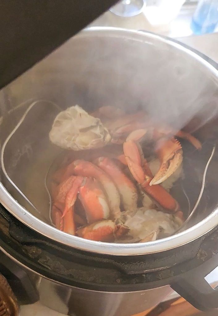 Opening instant pot after preparing pre-cooked Dungeness crab.