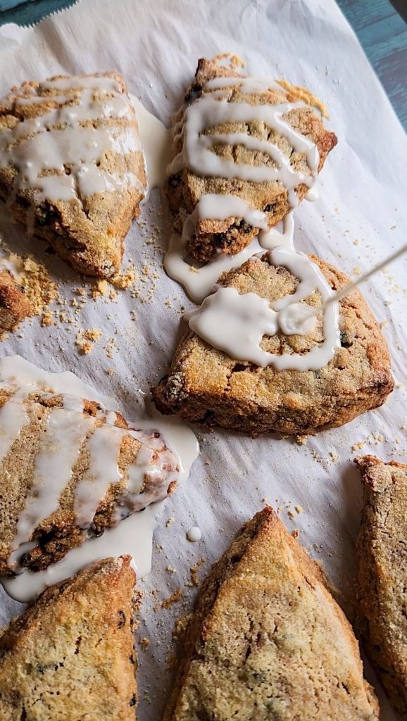 Pouring drizzle over gluten free scones.