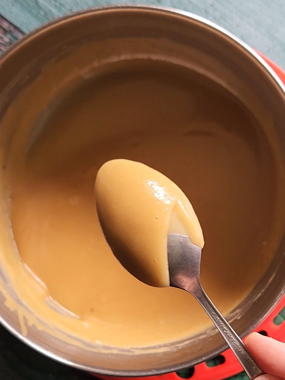 Checking thickness of maple glaze with a spoon.