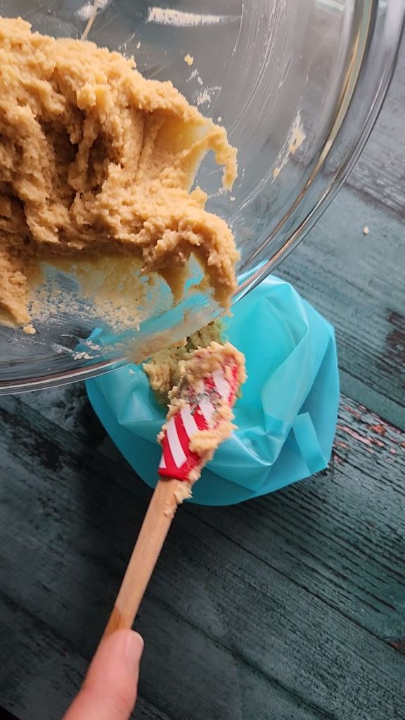 Adding gluten-free Maple Donuts batter to a piping bag.