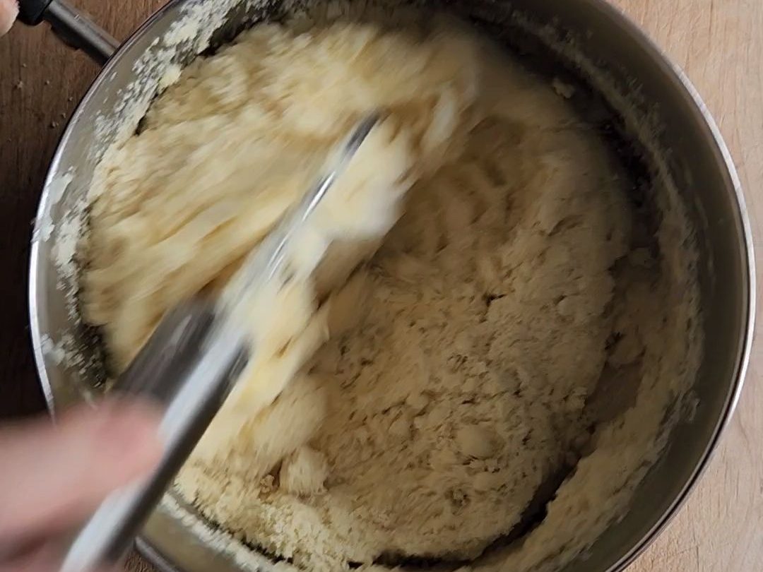 Mixing the flour into the melted cheeses.