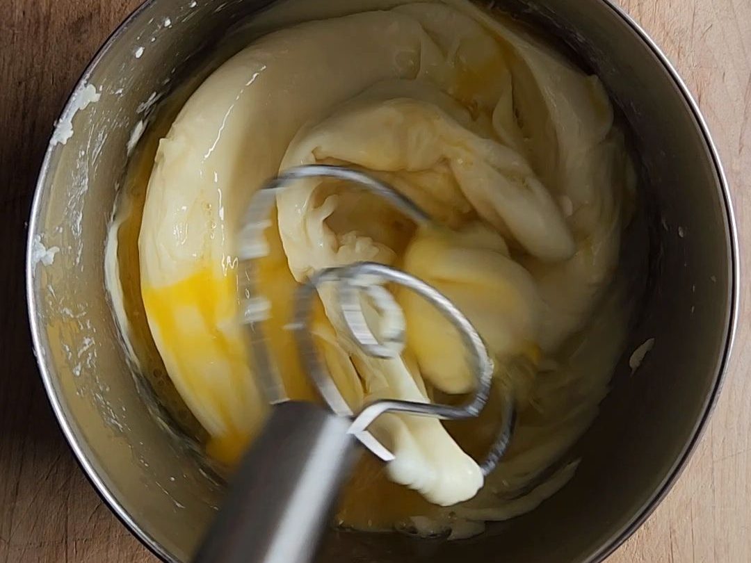 Mixing eggs into the melted cheeses for the crust.