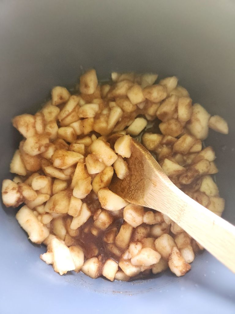 stirring chopped pears with spices inside instant pot.