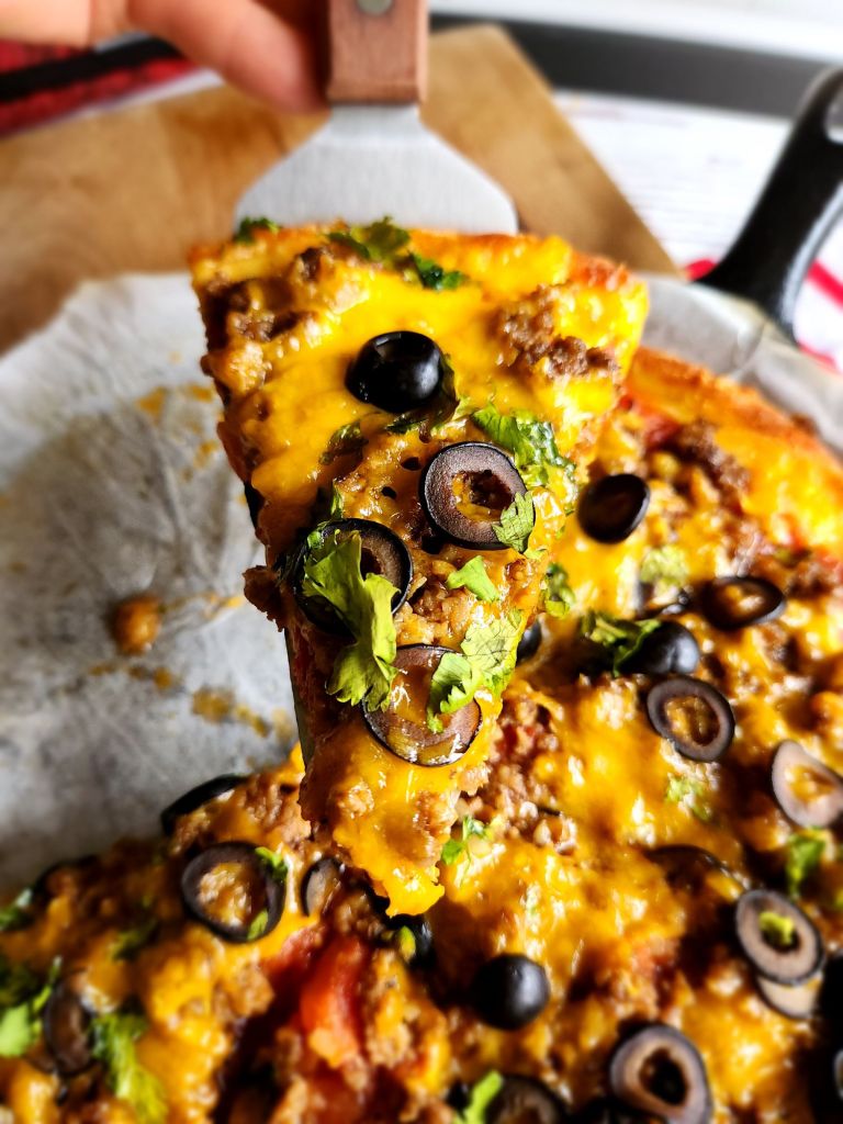 A piece of Gluten free keto copycat godfathers taco pizza being served up.