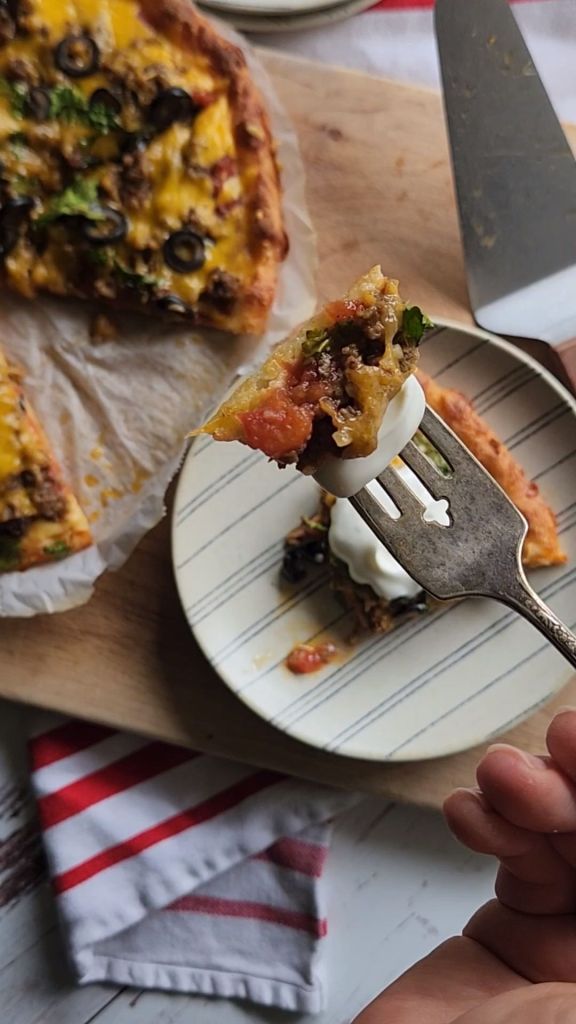 Gluten free keto copycat godfathers taco pizza topped with sour cream.