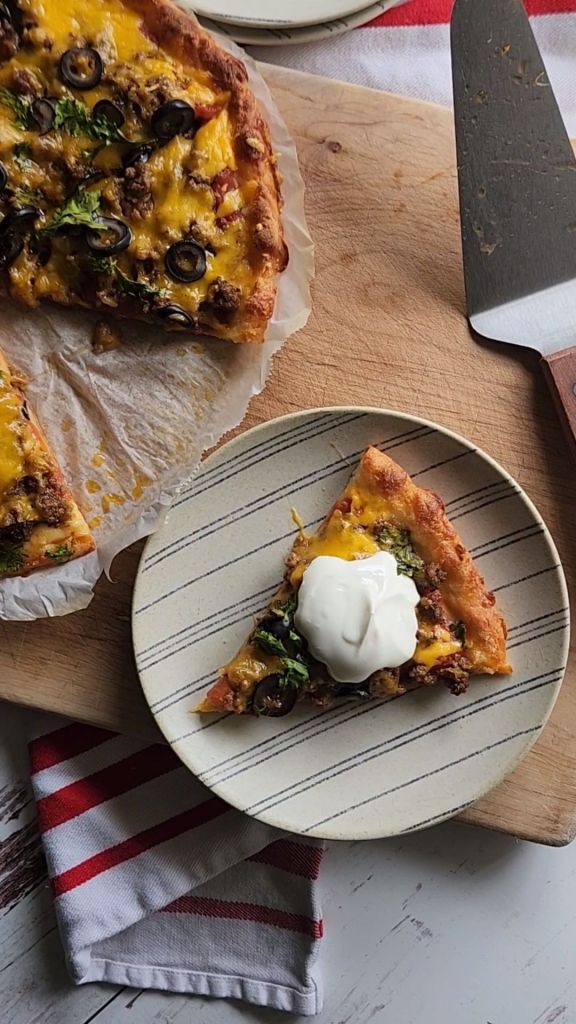 Gluten free keto copycat godfathers taco pizza topped with sour cream.