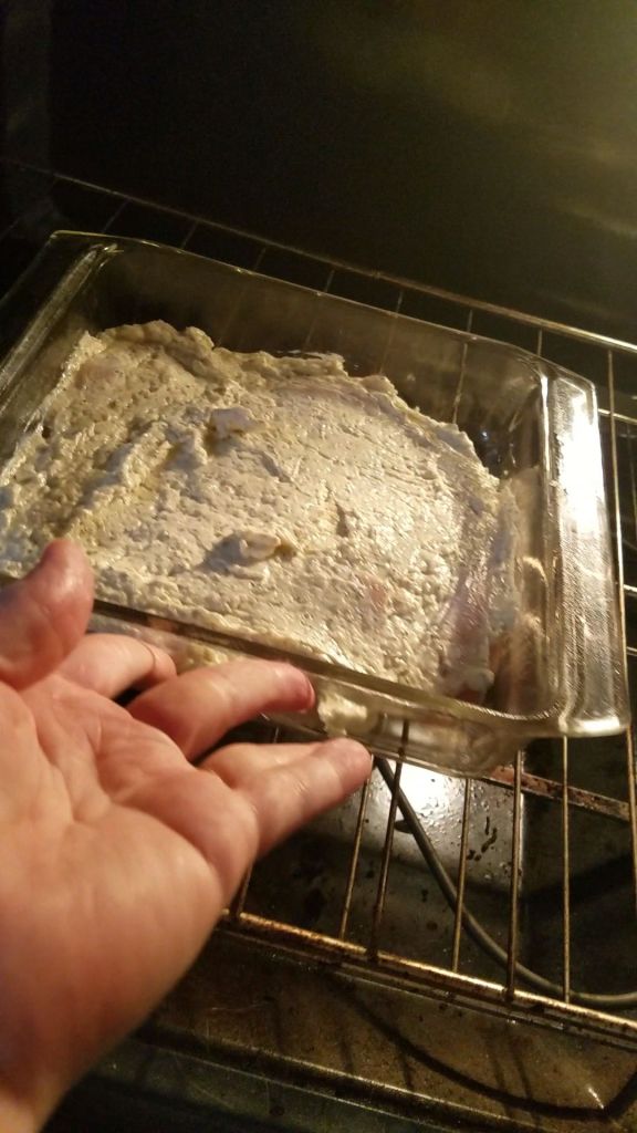 Putting gluten-free creamy Italian parmesan chicken dinner into the oven.