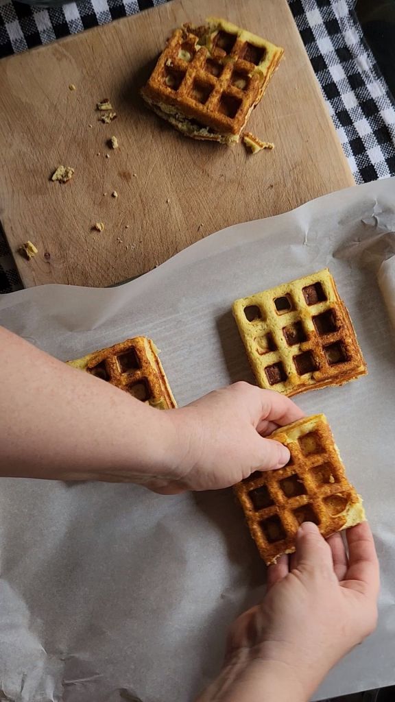 Placing prepared gluten-free keto mini pizza chaffles onto a baking sheet lined with parchment paper.