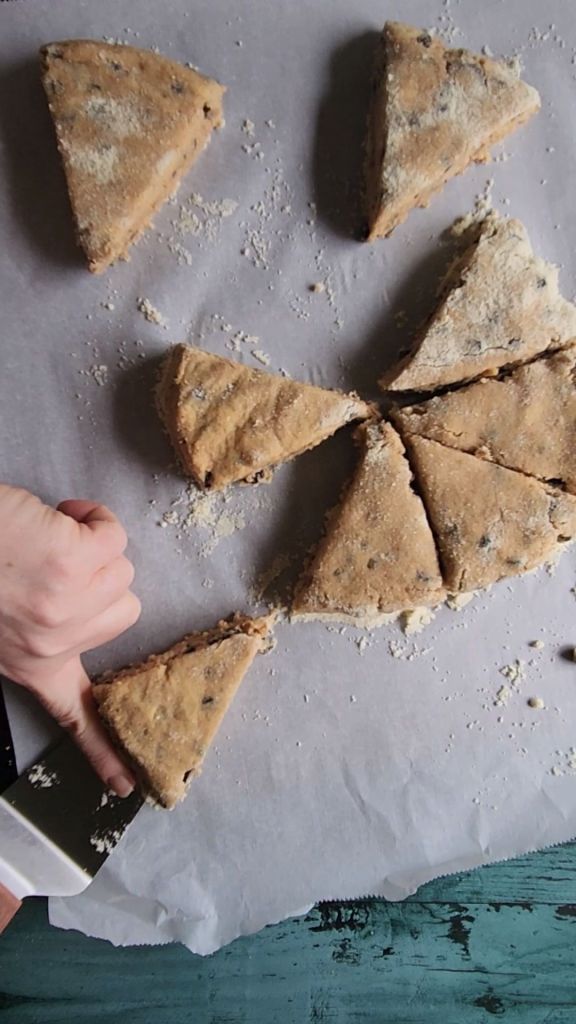 Separating scone dough on parchment line pan.