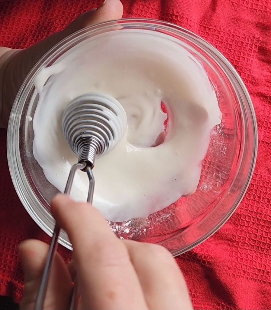 Whisking and drizzle to put over gluten free scones.