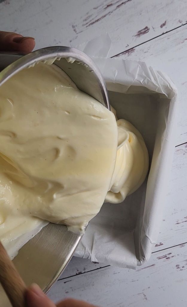 Pouring batter for gluten-free flourless Hawaiian keto bread into a parchment line pan.