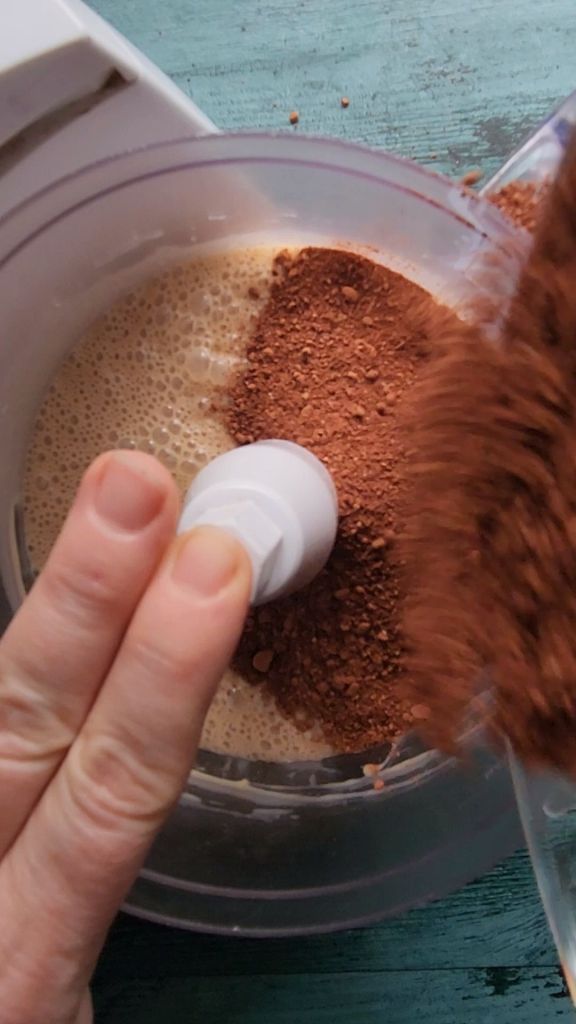 Adding dry ingredients to the wet ingredients to make gluten-free Bailey's Irish cream chocolate bundt cake.