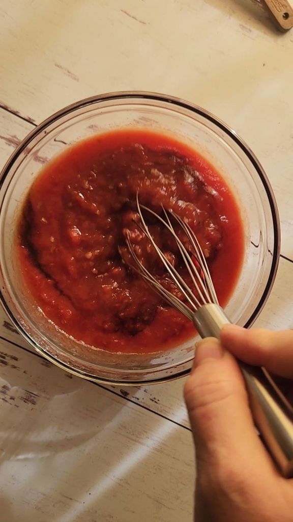 Mixing tomato sauce mixture for easy gluten free copycat McCormick Swiss steak recipe.