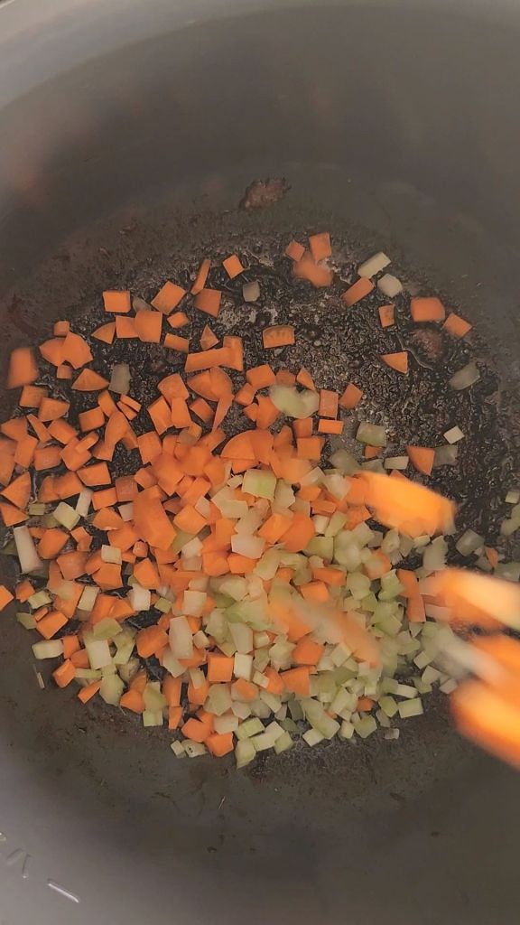Sauteing veggies and broth to deglaze instant pot for easy gluten-free copycat McCormick Swiss steak recipe.